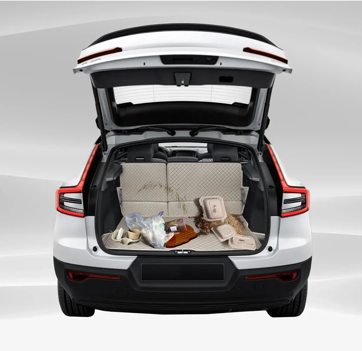 An SUV boot lined with a beige 3D mat, groceries and a spilled drink sitting on it