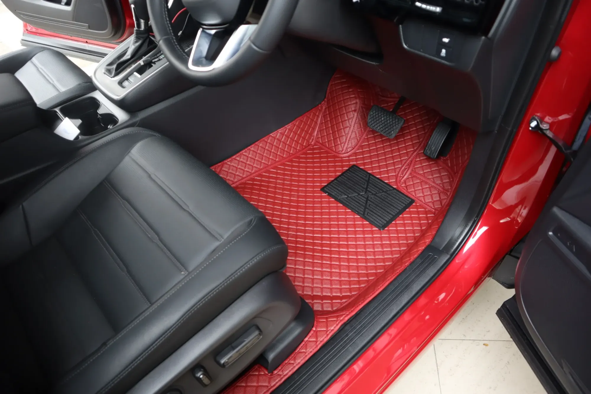 Red SUV driver's footwell with a red 3D car mat