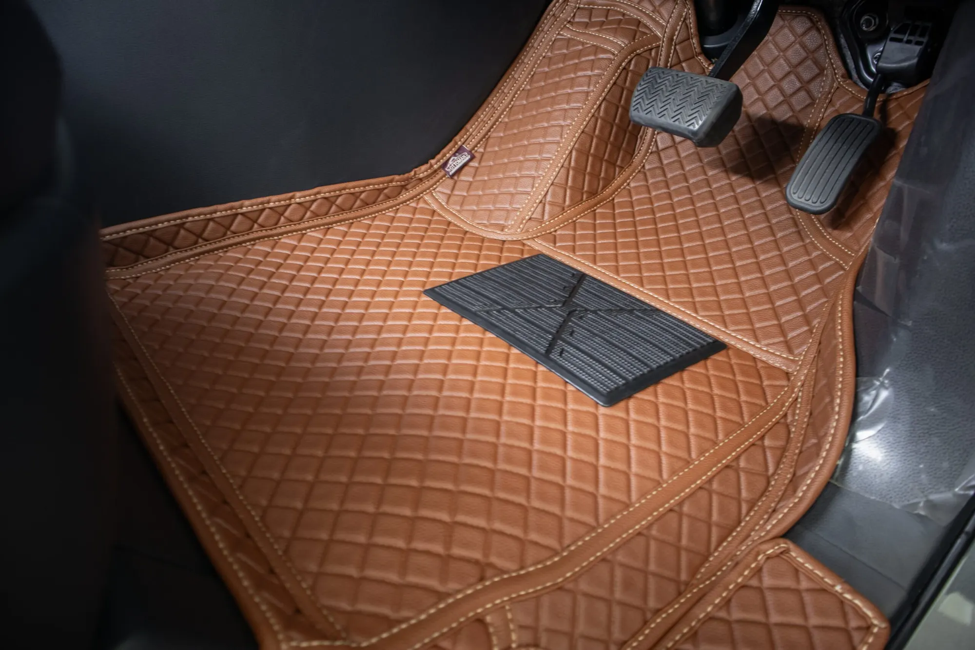 Driver's footwell of a seven-seater with a tan 3D car mat