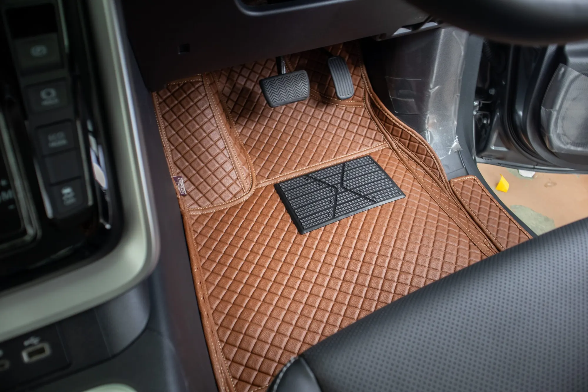 Passenger footwell of a seven-seater with a tan 3D car mat