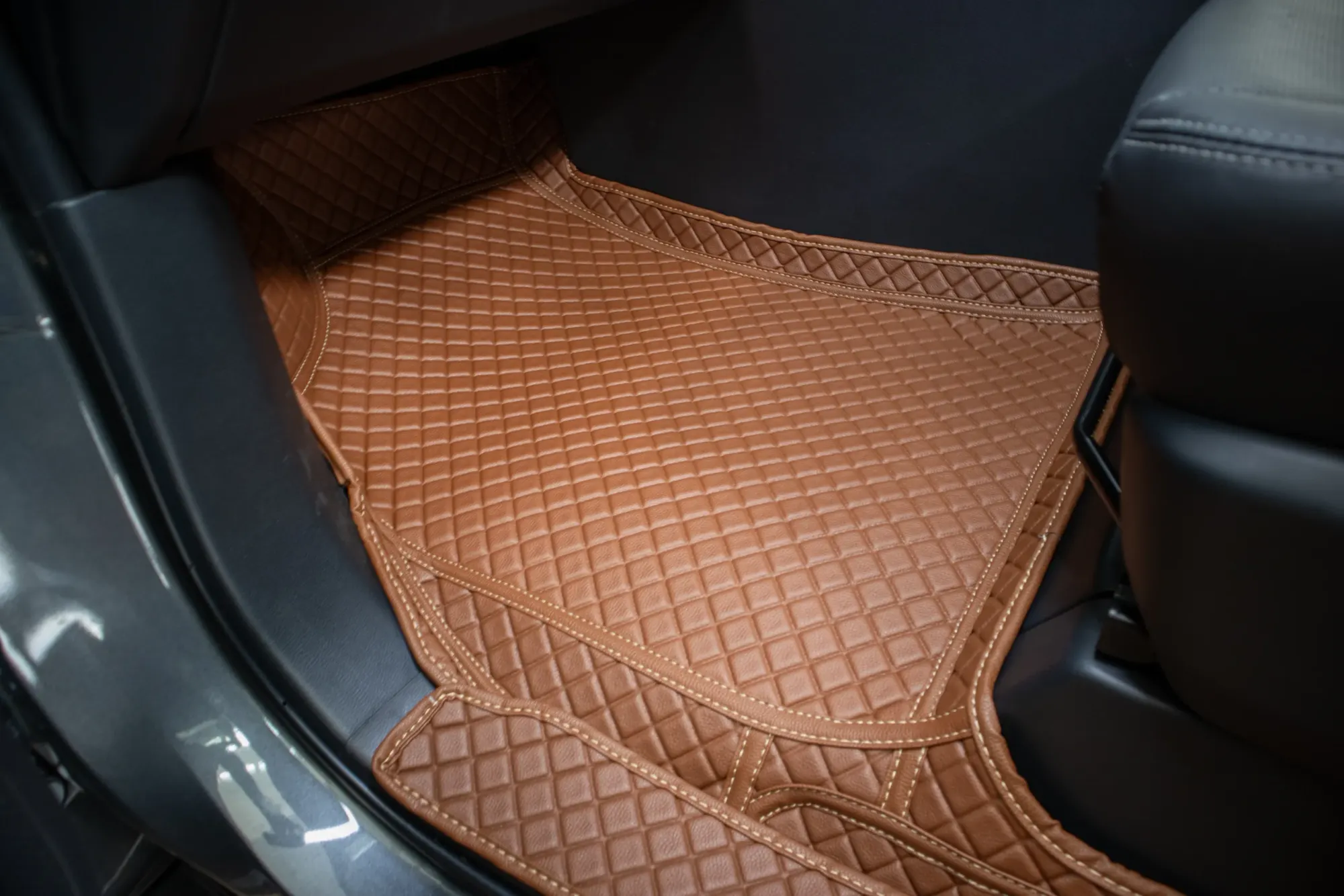 Front footwell of a seven-seater with a tan 3D car mat