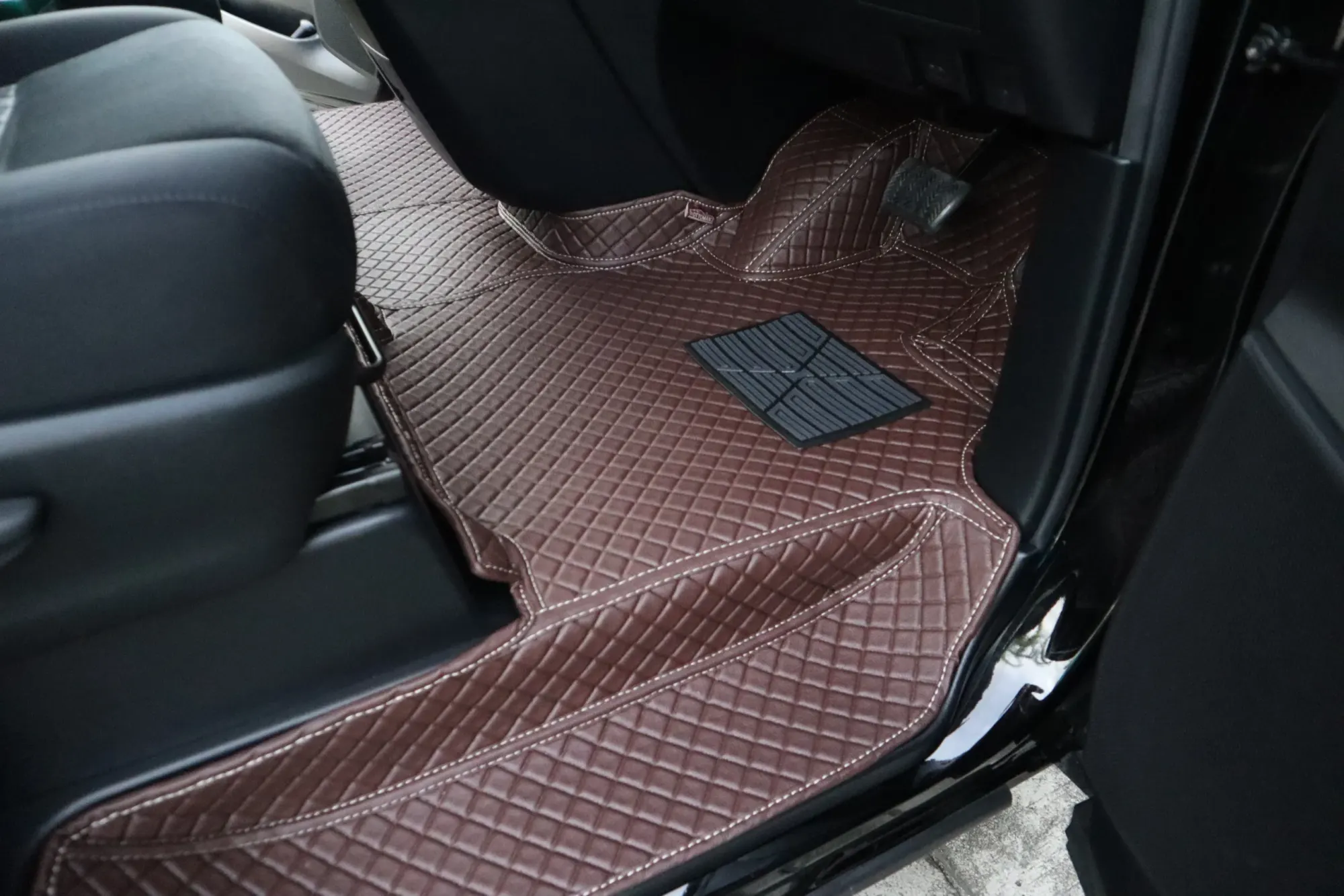 MPV passenger footwell with a brown 3D car mat