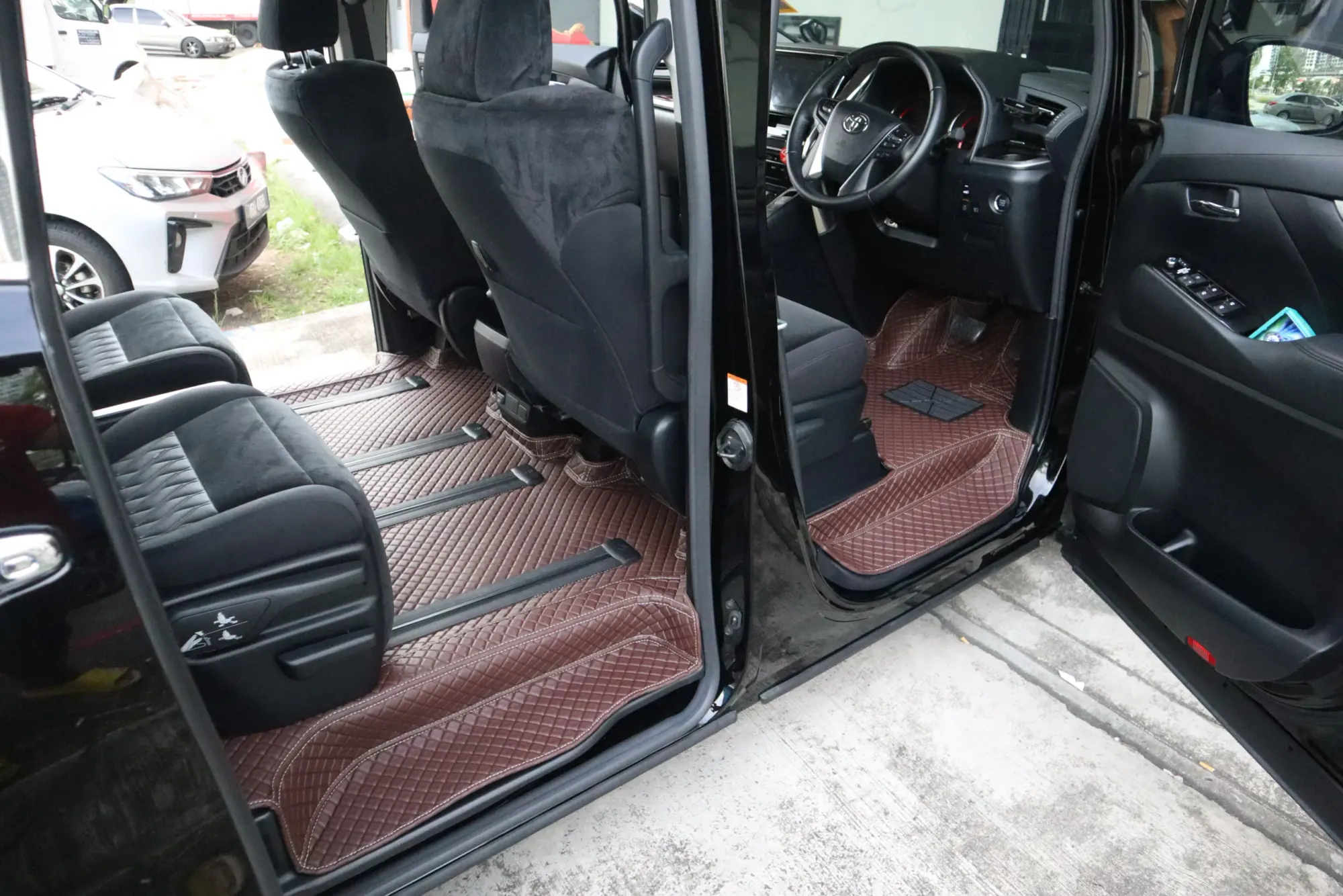 MPV cabin from the sliding door with brown 3D car mats on every row