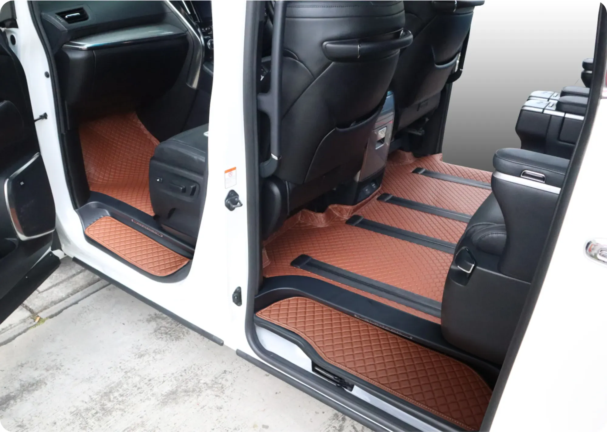 MPV sliding door open onto brown 3D car mats on every row