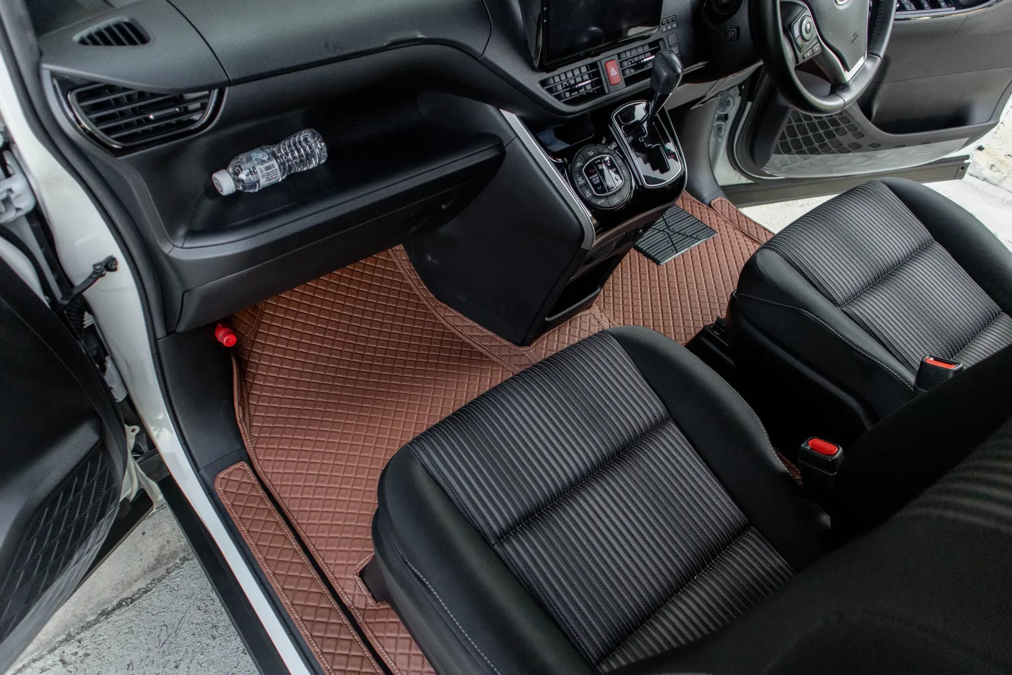Small MPV front footwell with a brown 3D car mat