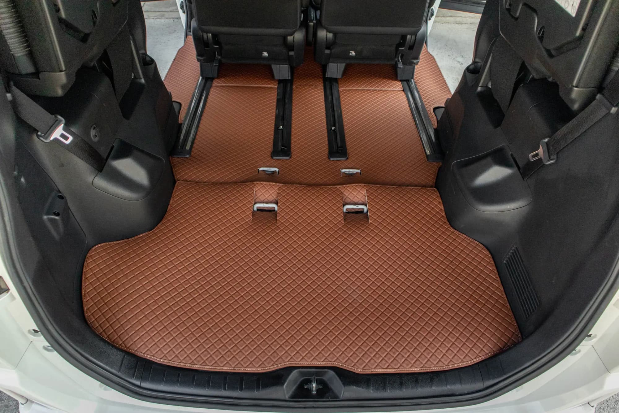 Small MPV with the rear seats folded, brown 3D car mat to the boot