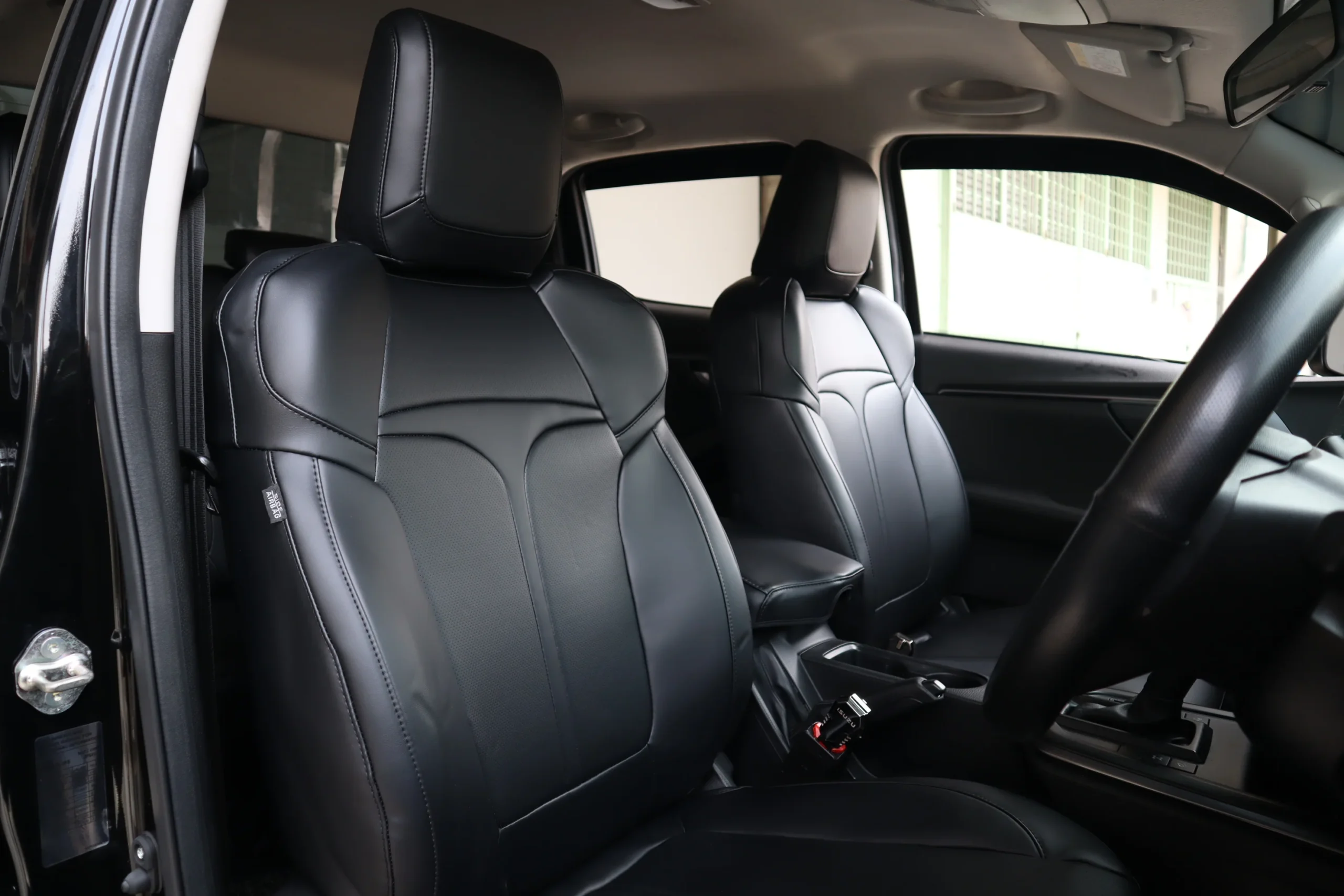 Front row fitted with black Titan seat covers, the T visible where the panels meet on each backrest