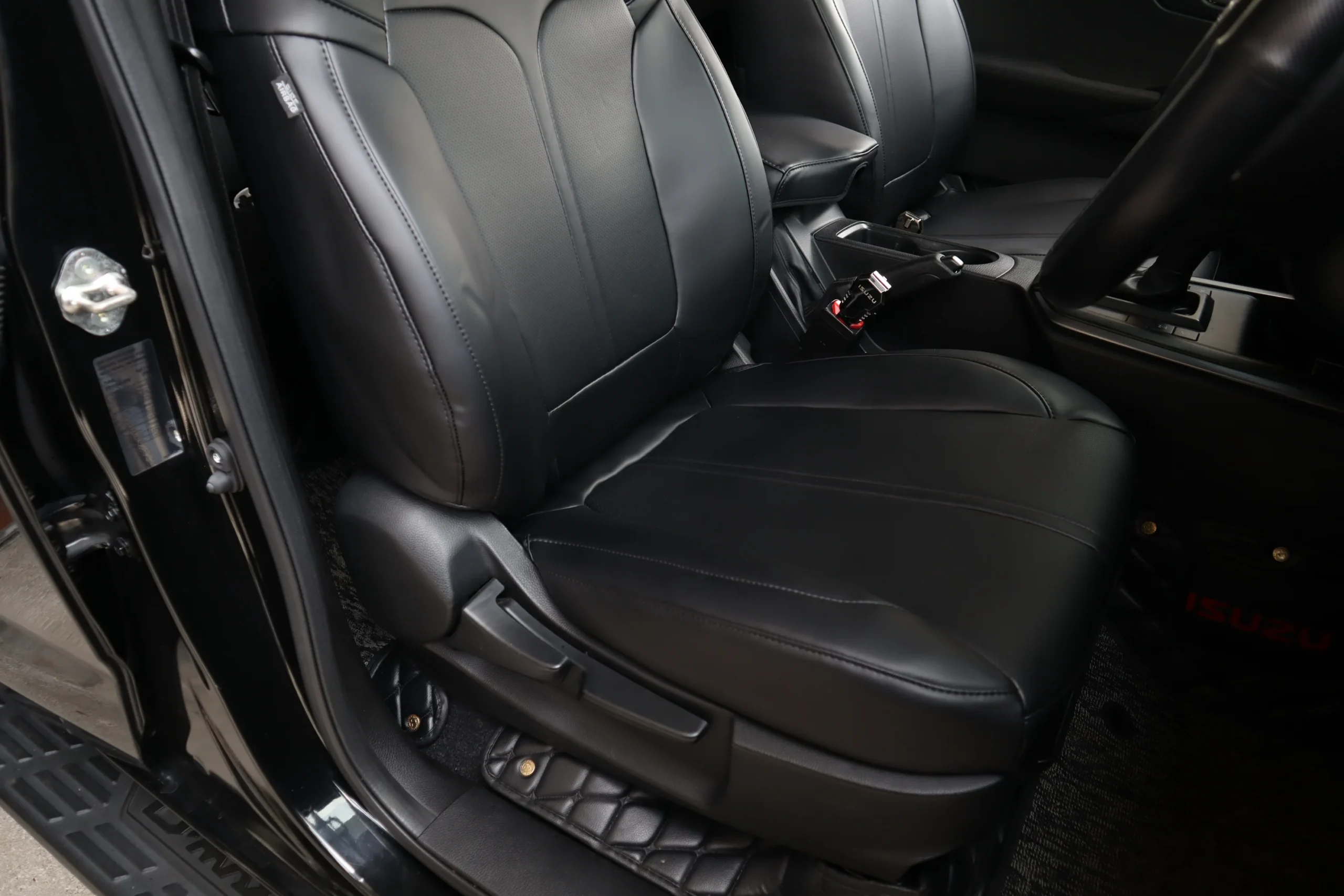 Driver's seat in black Titan covers, seen through the open door with the sill below