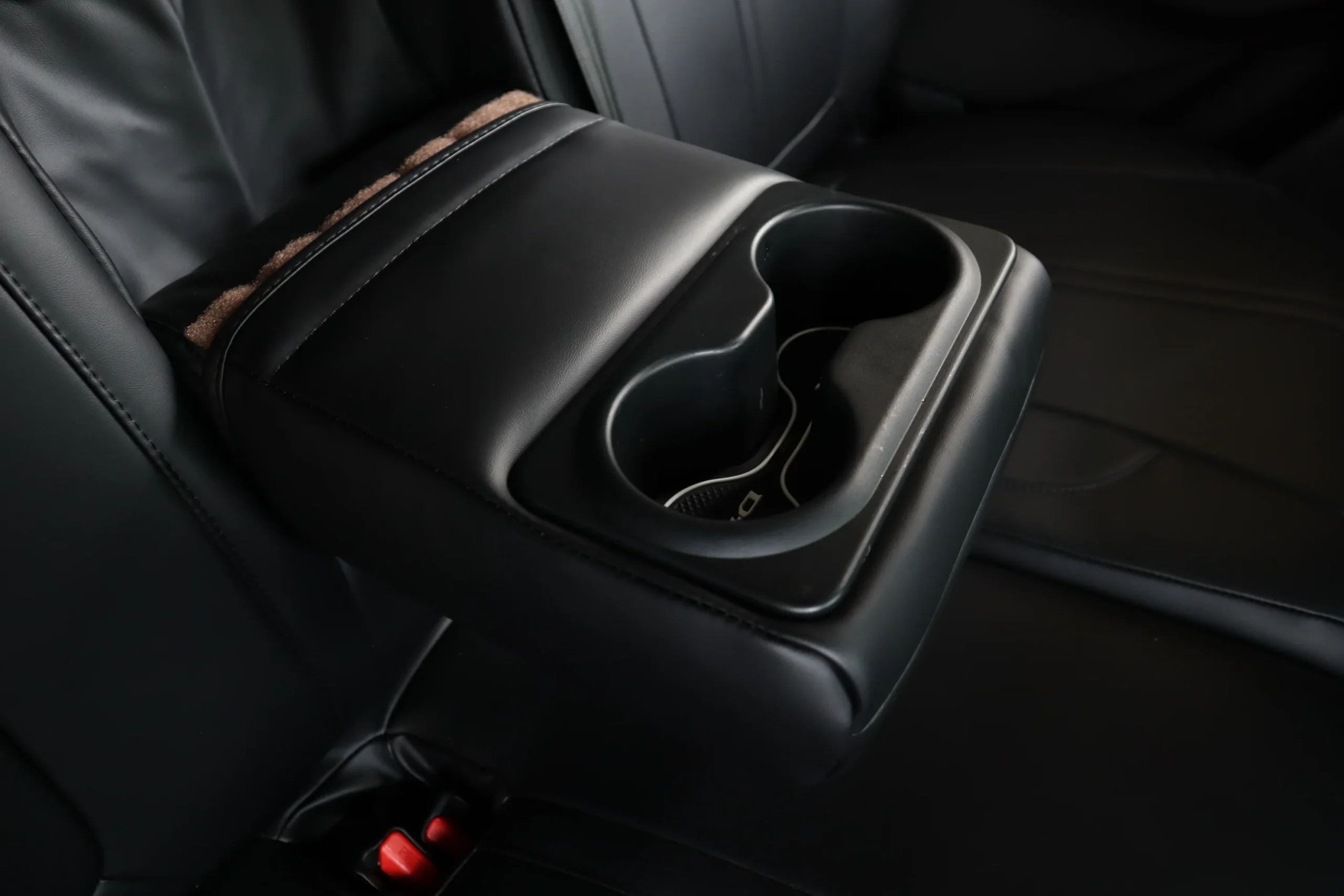 Rear armrest of a black Titan set folded down, the cup holders left open