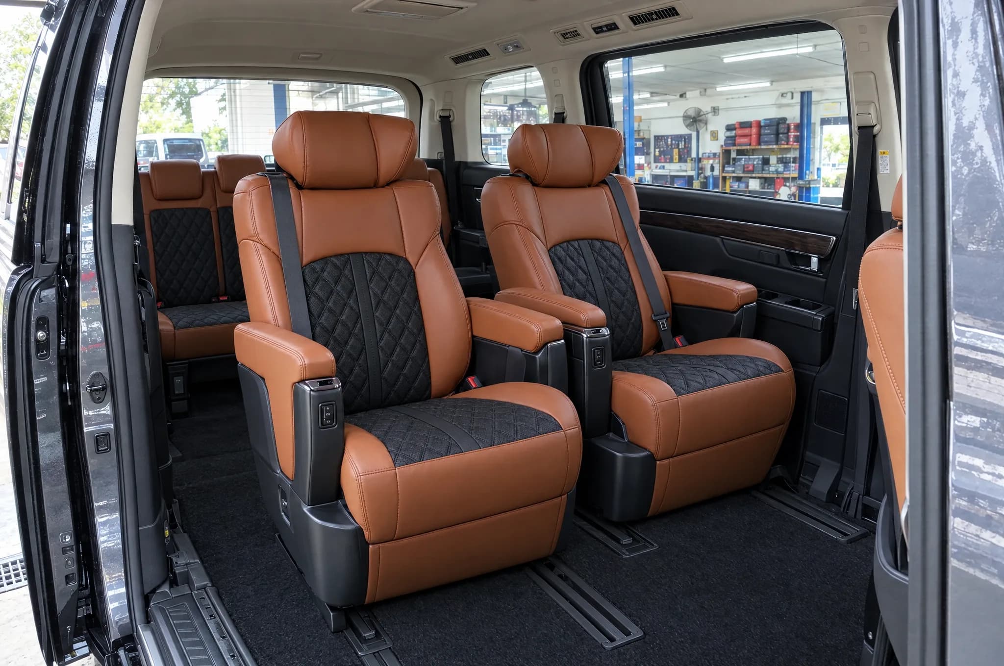 Render: Toyota Alphard captain chairs with cognac and black Adamas seat covers, seen through the sliding door